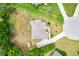 Overhead shot of a well-maintained home with a gray roof, green lawn, mature trees, and a private driveway at 10465 Se 41St Ter, Belleview, FL 34420