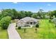 Sprawling property featuring a well-maintained home, lush greenery, an outbuilding, and a long driveway at 10465 Se 41St Ter, Belleview, FL 34420