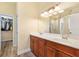 Bathroom featuring double sinks, granite countertops, and a walk-in closet at 10465 Se 41St Ter, Belleview, FL 34420