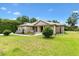 Beautiful front yard with manicured landscaping and a charming stucco home with stone accents and welcoming front porch at 10465 Se 41St Ter, Belleview, FL 34420