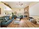 Comfortable living room with a stone fireplace, hardwood floors, a ceiling fan, and ample natural light at 10465 Se 41St Ter, Belleview, FL 34420