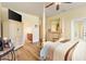 An airy main bedroom with a view to the en suite and featuring wood floors and a four-poster bed at 10465 Se 41St Ter, Belleview, FL 34420