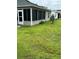 An expansive backyard features lush green grass and mature landscaping at 1060 Davenport Dr, The Villages, FL 32162