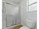 Bathroom with a glass-enclosed shower, toilet, and window, all designed for relaxation at 1060 Davenport Dr, The Villages, FL 32162