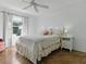 Cozy bedroom with large window, ceiling fan, and stylish bedside tables and lamps at 1060 Davenport Dr, The Villages, FL 32162