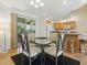 Open dining area next to the kitchen with a glass table, stylish chairs, and sliding doors to the lanai at 1060 Davenport Dr, The Villages, FL 32162