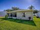 Side exterior view of a one story home with a grassy lawn and some foliage at 1060 Davenport Dr, The Villages, FL 32162