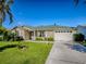 Well-maintained single-story home featuring an attached garage, and a green lawn in a quiet neighborhood at 1060 Davenport Dr, The Villages, FL 32162