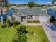 Charming single-story home featuring a well-manicured lawn, an attached garage, and mature landscaping at 1060 Davenport Dr, The Villages, FL 32162