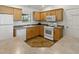 A clean kitchen featuring wood cabinets and white appliances at 1060 Davenport Dr, The Villages, FL 32162