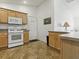 A view of the kitchen featuring wood cabinets and white appliances at 1060 Davenport Dr, The Villages, FL 32162
