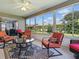 Enclosed sunroom with comfortable seating, a ceiling fan, and views of the surrounding landscape at 1060 Davenport Dr, The Villages, FL 32162