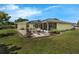 A well-manicured backyard with patio, outdoor seating, and verdant, lush landscaping at 111 Ridgeview Cir, Eustis, FL 32726