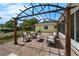 Backyard with brick patio, a pergola, outdoor seating, and lush, maintained greenery at 111 Ridgeview Cir, Eustis, FL 32726