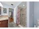 Bathroom features a tiled shower, blue walls, vanity, and open doorway at 111 Ridgeview Cir, Eustis, FL 32726