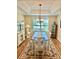 Elegant dining room featuring tray ceiling, wood floors, a decorative rug, and large windows at 11277 Se 170Th Ln, Summerfield, FL 34491