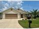 Charming single-story home featuring a manicured lawn, well-maintained landscaping, and a two-car garage at 11277 Se 170Th Ln, Summerfield, FL 34491