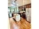 Modern kitchen with granite countertops, stainless steel appliances, a center island, and hardwood floors at 11277 Se 170Th Ln, Summerfield, FL 34491