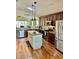 Well-lit kitchen featuring stainless steel appliances, center island, and beautiful wood flooring at 11277 Se 170Th Ln, Summerfield, FL 34491