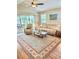 Bright living room featuring a ceiling fan, tan sofa, recliner, and sliding glass doors leading to the outdoor patio at 11277 Se 170Th Ln, Summerfield, FL 34491