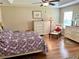 Comfortable main bedroom with wood flooring, a ceiling fan, and a dresser with mirror offering plenty of storage at 11277 Se 170Th Ln, Summerfield, FL 34491
