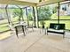 Screened patio with dining table and chairs and a bench offering a relaxing outdoor space at 11277 Se 170Th Ln, Summerfield, FL 34491