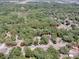 Aerial view of a tree covered residential area with a red boundary line over two lots at 1203 High St, Wildwood, FL 34785