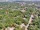 Aerial view of a tree covered residential area with a red boundary line over two lots at 1203 High St, Wildwood, FL 34785