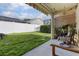 The covered patio opens to the fenced backyard with green grass and seating area at 12430 Ne 52Nd Loop, Oxford, FL 34484