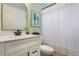 Bright and modern bathroom features a white vanity, updated fixtures and shiplap accent wall at 12430 Ne 52Nd Loop, Oxford, FL 34484