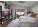 Comfortable bedroom featuring a vaulted ceiling, sliding glass doors and a modern entertainment center at 12430 Ne 52Nd Loop, Oxford, FL 34484