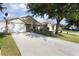 Inviting one-story home with well manicured lawn, long driveway, and an attached two-car garage at 12430 Ne 52Nd Loop, Oxford, FL 34484