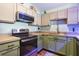 Well-equipped kitchen featuring stainless steel appliances, modern fixtures, and efficient layout at 12430 Ne 52Nd Loop, Oxford, FL 34484