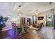 Open-concept living and dining area with wood floors, modern light fixture, and comfortable seating at 12430 Ne 52Nd Loop, Oxford, FL 34484
