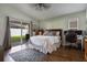 Bright main bedroom with wood floors, sliding glass doors to backyard, and functional workstation at 12430 Ne 52Nd Loop, Oxford, FL 34484