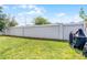 Fenced backyard with lush grass and a barbecue grill, perfect for outdoor entertaining at 1247 Mezzavalle Way, Auburndale, FL 33823