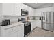 Modern kitchen featuring stainless steel appliances, white cabinets, and spacious countertops at 1247 Mezzavalle Way, Auburndale, FL 33823