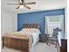 Bedroom with blue accent wall, plush carpet, and comfortable bedding at 1247 Mezzavalle Way, Auburndale, FL 33823