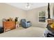 Comfortable carpeted bedroom with an accent chair, window, and ceiling fan at 12512 Lake Ridge Cir, Clermont, FL 34711