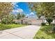 Inviting home with a long driveway and an attached two-car garage, surrounded by mature trees and manicured lawn at 12512 Lake Ridge Cir, Clermont, FL 34711