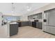 Open kitchen features gray cabinets, stainless steel appliances, light countertops, and light flooring at 12512 Lake Ridge Cir, Clermont, FL 34711