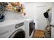 Bright laundry room with modern appliances, storage shelves, and easy access to a side door at 12512 Lake Ridge Cir, Clermont, FL 34711