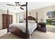 Elegant main bedroom featuring a four-poster bed, soft lighting, and serene views from the windows at 12512 Lake Ridge Cir, Clermont, FL 34711