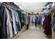 Organized walk-in closet with multiple rods and shelves for clothing, shoes, and storage at 12512 Lake Ridge Cir, Clermont, FL 34711