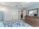 Bedroom with natural light, ceiling fan, closet, dresser, and doorway leading to another room at 1309 Piney Woods Path, The Villages, FL 32163