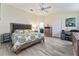 Bright bedroom with a ceiling fan, light-colored walls, wood floors, and a patterned quilt on the bed at 1309 Piney Woods Path, The Villages, FL 32163