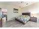 Bright bedroom features wood-look tile, modern ceiling fan, and ensuite bathroom access at 1309 Piney Woods Path, The Villages, FL 32163