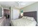 This cozy bedroom includes a ceiling fan, a queen-sized bed, natural light and view to a dining room at 1309 Piney Woods Path, The Villages, FL 32163