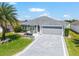 Beautiful home exterior with manicured lawn, hardscape and spacious driveway at 1309 Piney Woods Path, The Villages, FL 32163