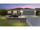 Charming home featuring a landscaped yard, patio, and attached two-car garage at 1309 Piney Woods Path, The Villages, FL 32163